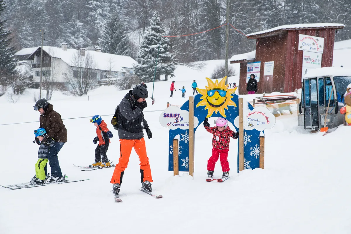 Kinder und Eltern beim Skifahren.